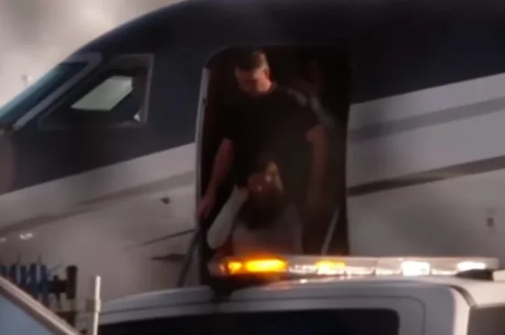 Homem desce de jato particular em aeroporto, com viatura ao lado